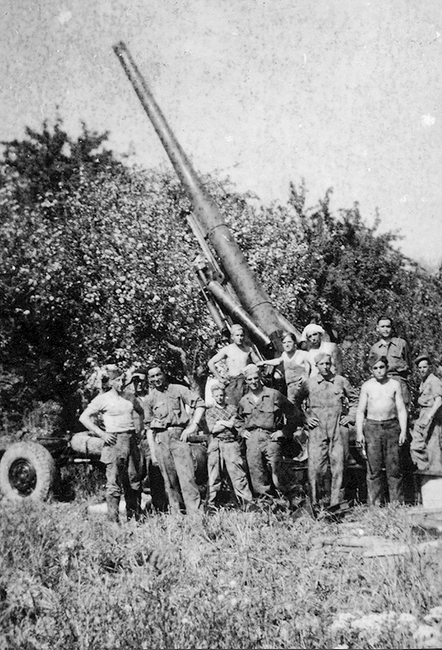 In the center of the photo Bernard Blin in front of an American artillery gun, “Long Tom”, 155mm, 1945. © Private Collection