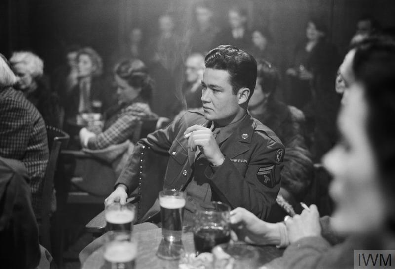 PUBLIC HOUSE DEBATE: DEBATING SOCIETY MEETINGS AT 'THE FREEMASON'S ARMS', HAMPSTEAD, LONDON, ENGLAND, UK, 1945 (D 23665) An American soldier is amongst the audience listening to the second speaker of the evening, Miss Crooks (not pictured), on the topic of 'America and Britain'. The original caption states that 'the few Americans present were unusually tongue-tied, had nothing to say to frank discussion of their qualities'. Miss Crooks is American, and works as a liaison between American and British women's services... Copyright: © IWM. Original Source: http://www.iwm.org.uk/collections/item/object/205201584