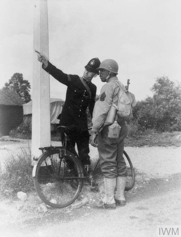 AMERICANS IN BRITAIN, 1942 - 1945 (HU 54542) Black GIs in Britain: Black American soldier in Britain, Elco Bolton from Florida, being given directions by a British police officer, 30 June 1942. Copyright: © IWM. Original Source: http://www.iwm.org.uk/collections/item/object/205086947