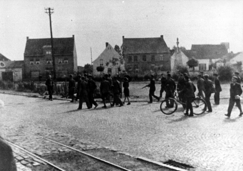 Après le massacre de Quevaucamps (Place du Pâturage, 1944), un groupe de Partisans Armés traverse la place avec 5 soldats allemands capturés à Aubechie.